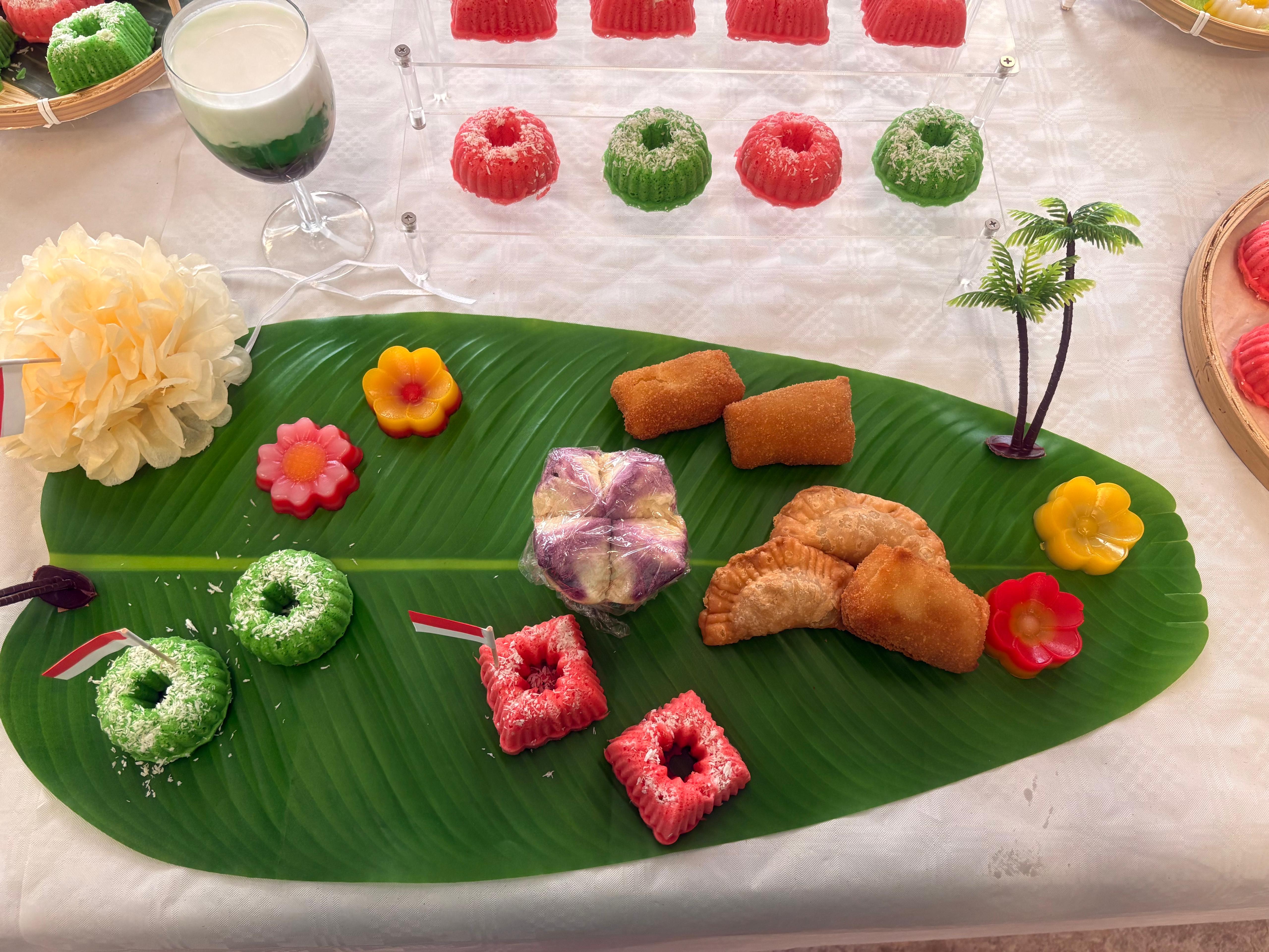Dessertpresentatie op bananenblad met kleurrijke kue
