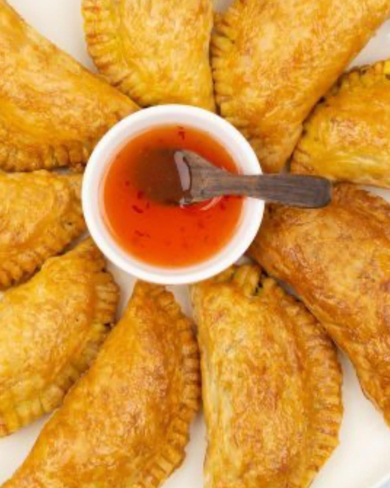 Hartige pasteitjes rondom een schaaltje chilisaus